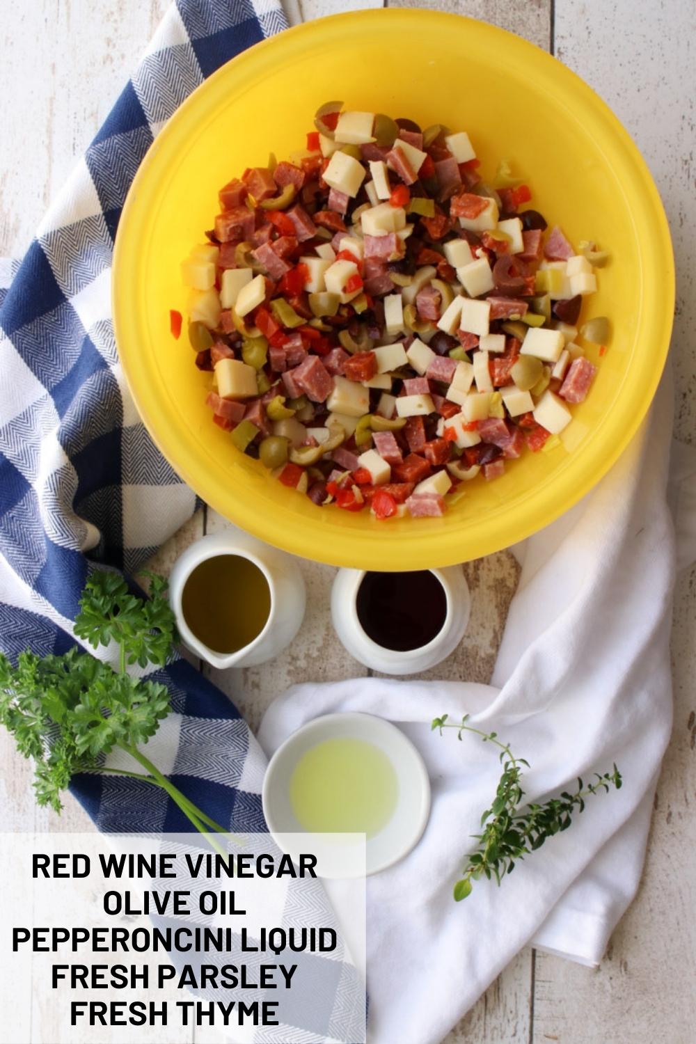 bowl of olive salad with small cups of dressing mixtue