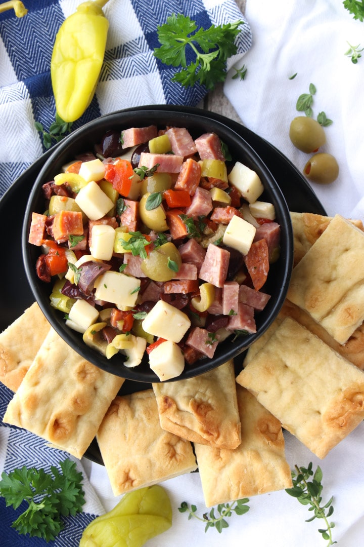 black bowl filled with dip and surrounded by crackers