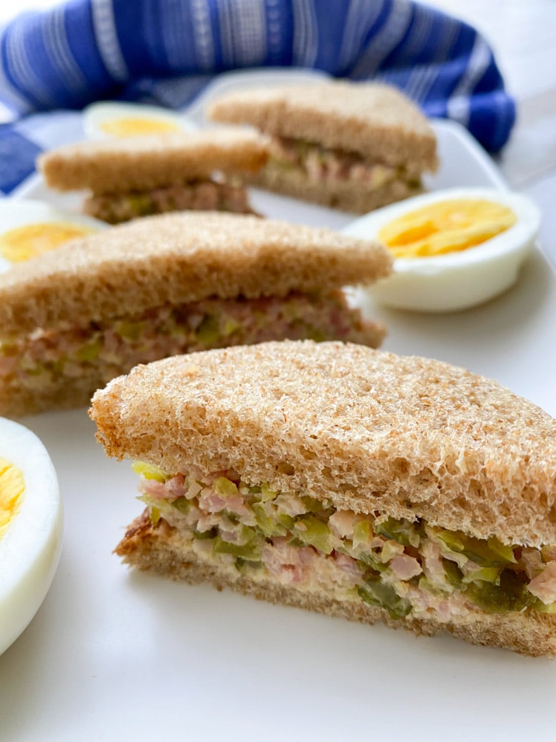 ham salad sandwiches and hardboiled eggs on a white plate