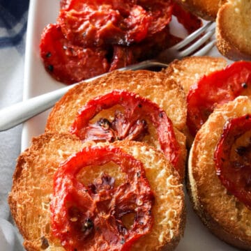 platter of roasted tomatoes on grill toast