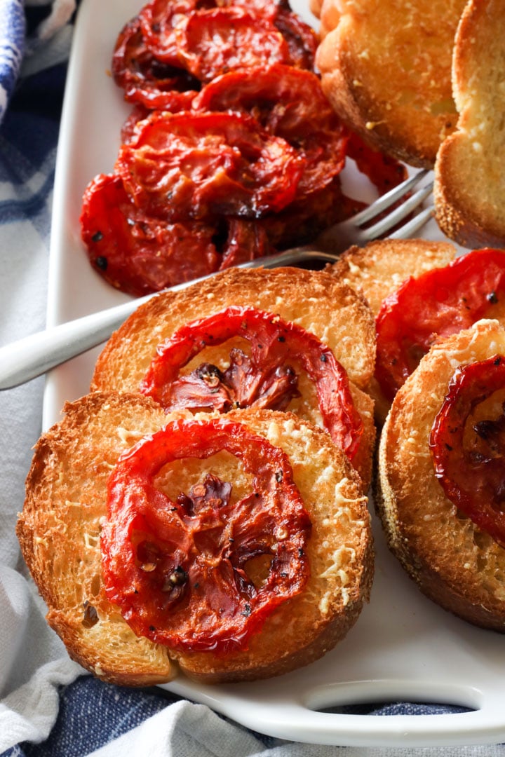 platter of roasted tomatoes on grill toast