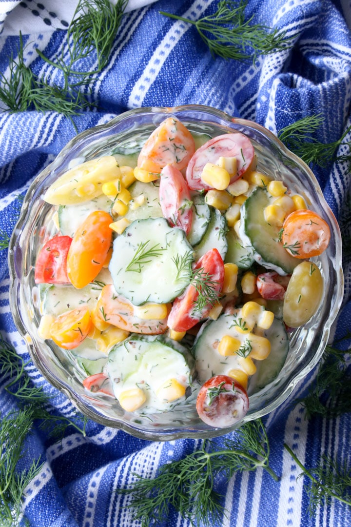 BOWL OF CREAMY CUCUMBER SALAD ON A BLUE AND WHITE TOWEL