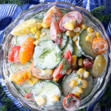 BOWL OF CREAMY CUCUMBER SALAD ON A BLUE AND WHITE TOWEL