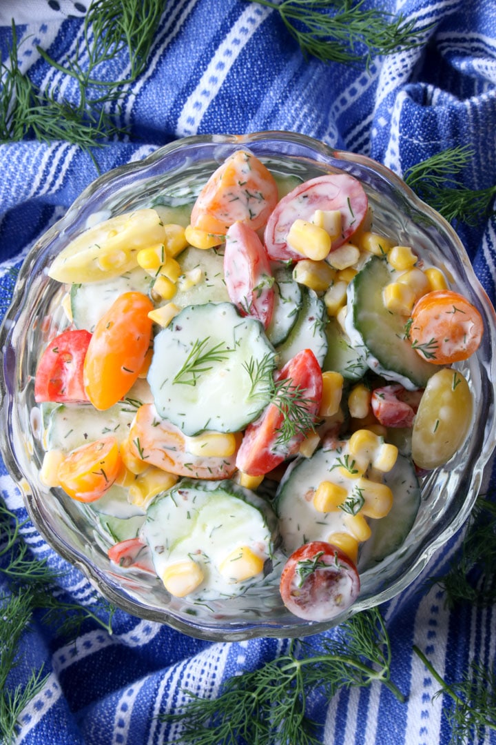 BOWL OF CREAMY CUCUMBER SALAD ON A BLUE AND WHITE TOWEL