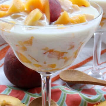 A DESSERT DISH FILLED WITH PEACHES IN A CREAM SAUCE