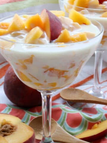 A DESSERT DISH FILLED WITH PEACHES IN A CREAM SAUCE