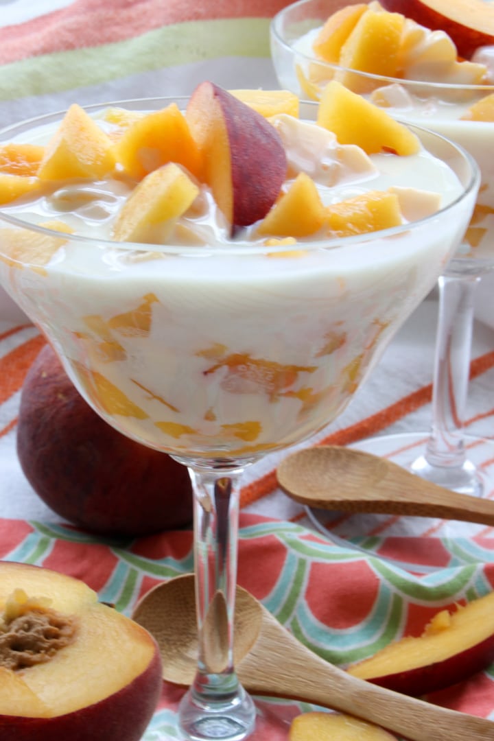 A DESSERT DISH FILLED WITH PEACHES IN A CREAM SAUCE