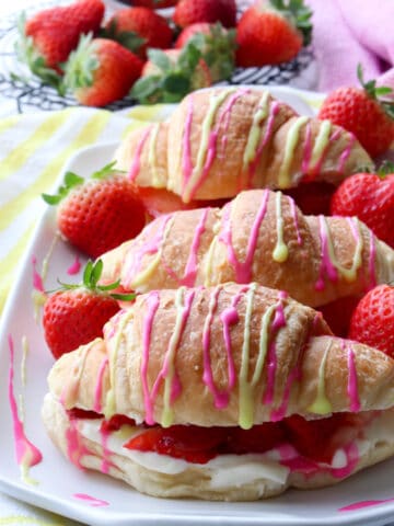 platter of croissants drizzled with pink and yellow glaze