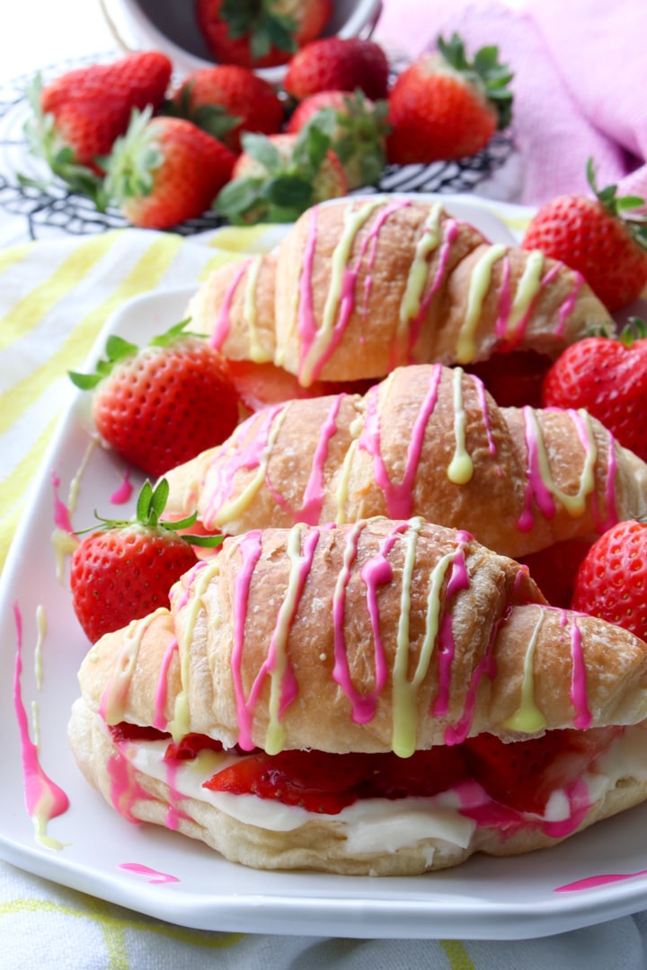 platter of croissants drizzled with pink and yellow glaze