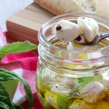 jar of marinated mozzarella balls with two on a fork