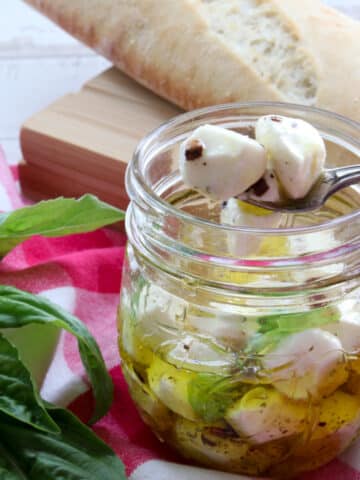 jar of marinated mozzarella balls with two on a fork