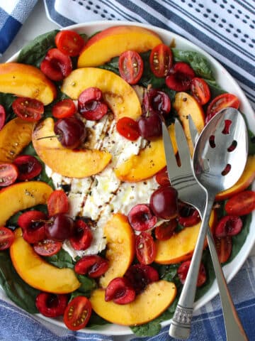 round platter of burrata, nectarines, cherries, tomatoes, spinach