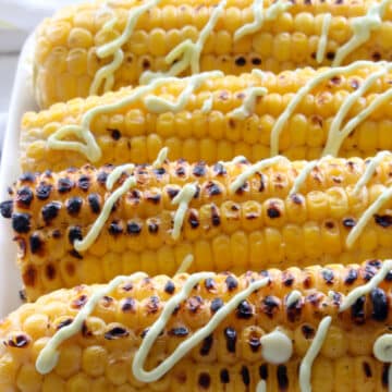 grilled corn on the cob with a drizzle of a avocado sauce