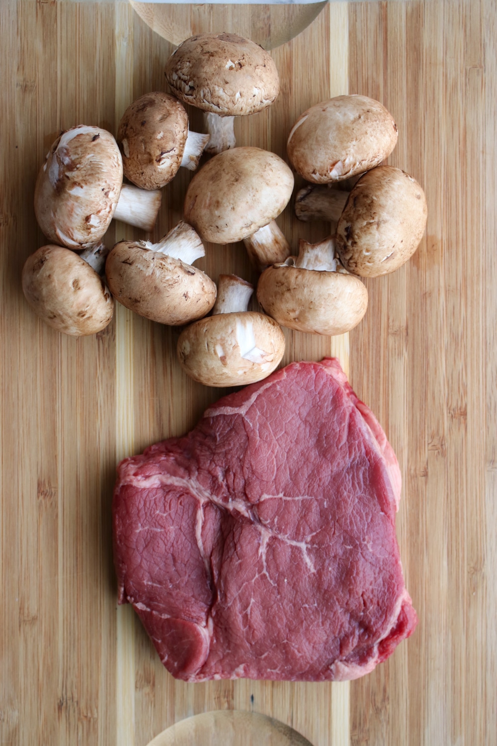 steak and mushrooms on a cutting board