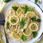 dish of lemon pasta with sliced lemons and fresh basil on top