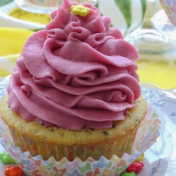 lemon poppy seed cupcake topped with a bright pink swirling frosting