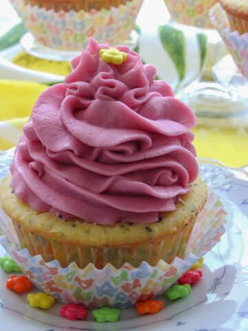 lemon poppy seed cupcake topped with a bright pink swirling frosting