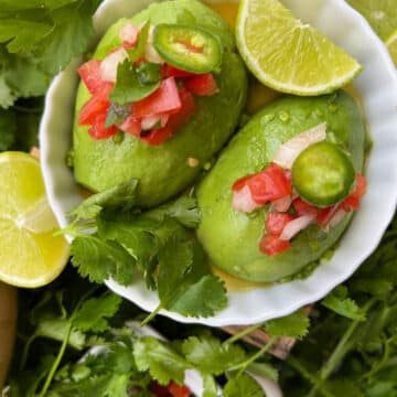 avocado in a bowl topped with salasa