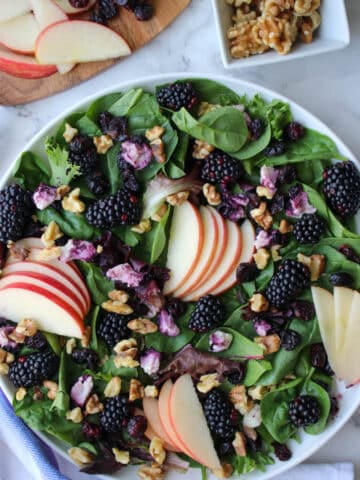 platter of mixed greens, apple slices, berries and goat cheese