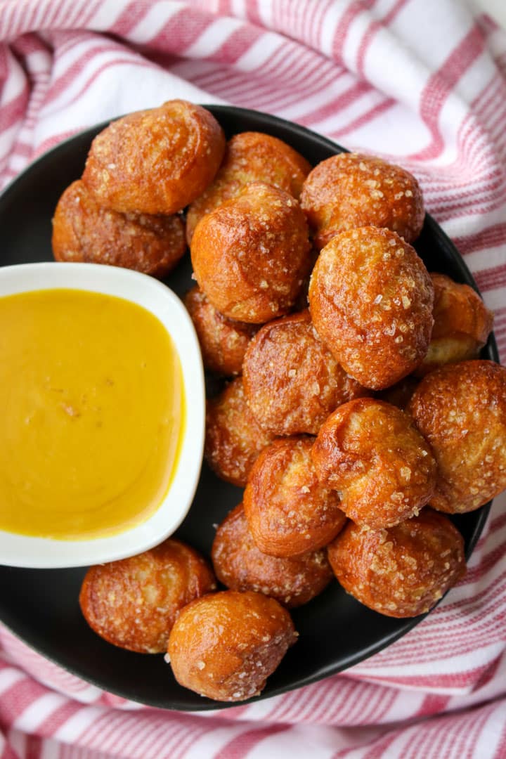 Black dish filled with pretzel bites and a small bowl of honey mustard sauce