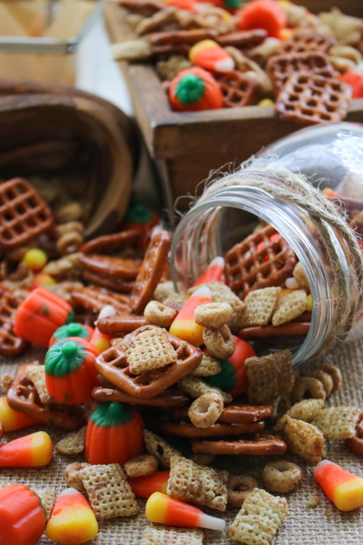 pumpkin pie spice party mix spilling out of tipped over jar