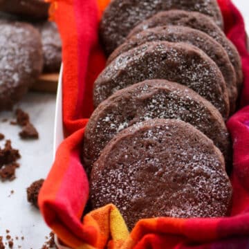 Mexican hot chocolate cookies in a box lined up one behind another. Crumb surrounding box