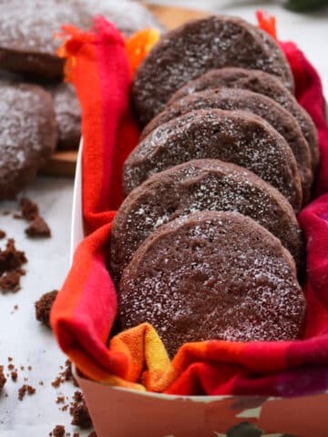 Mexican hot chocolate cookies in a box lined up one behind another. Crumb surrounding box