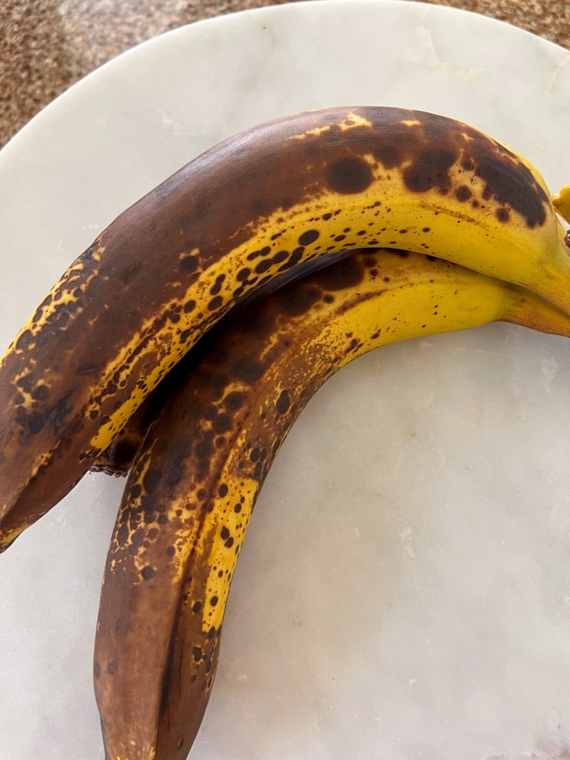 two over-ripe bananas on a plate