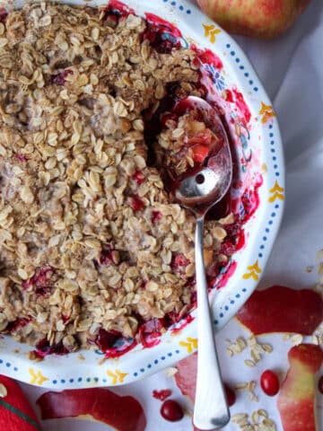 baking dish of cranberry apple crisp with a spoon