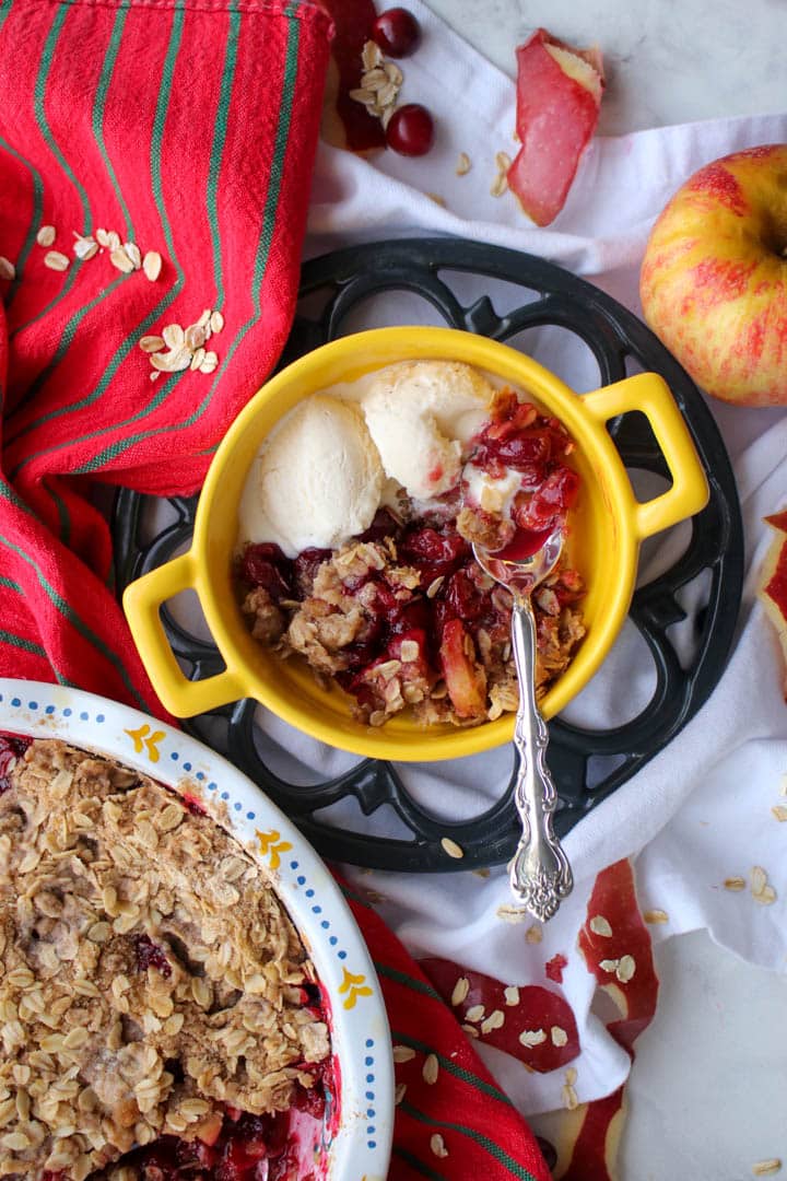 yellow bowl with handles with cranberry apple crisp and 2 scoops of ice cream