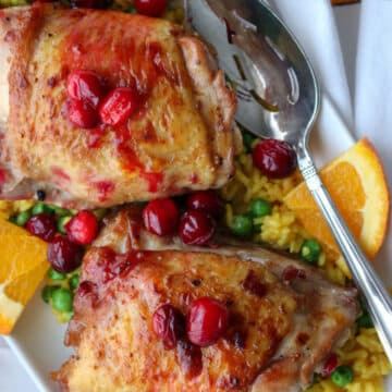 platter with yellow rice and peas topped with bake cranberry chicken