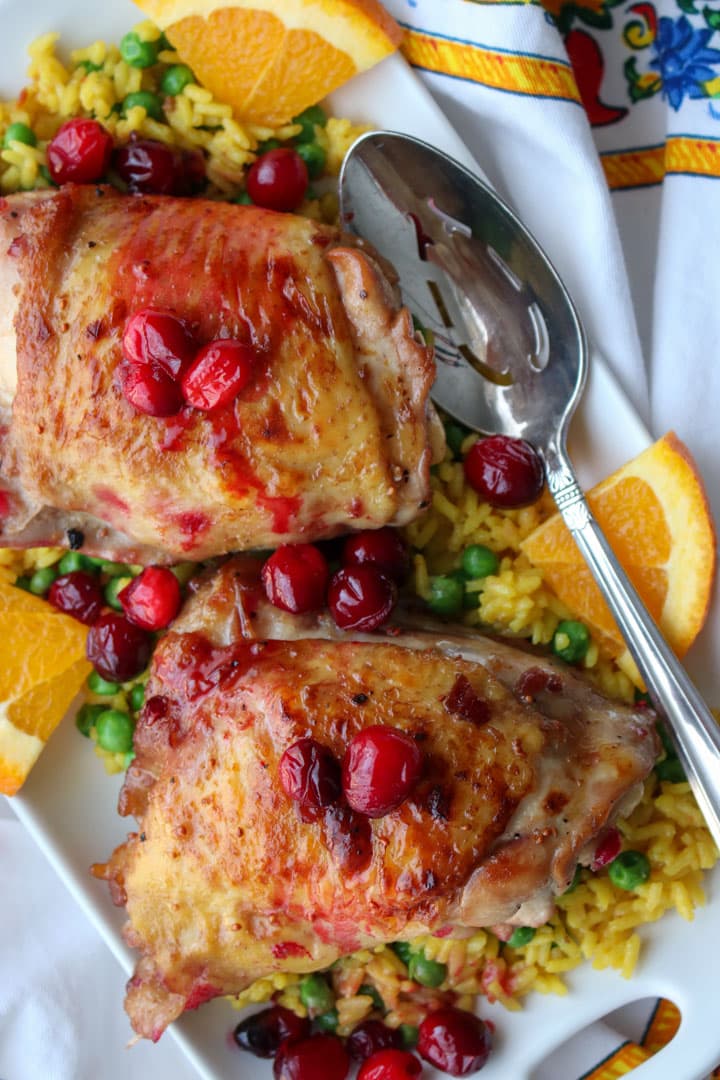 platter with yellow rice and peas topped with bake cranberry chicken