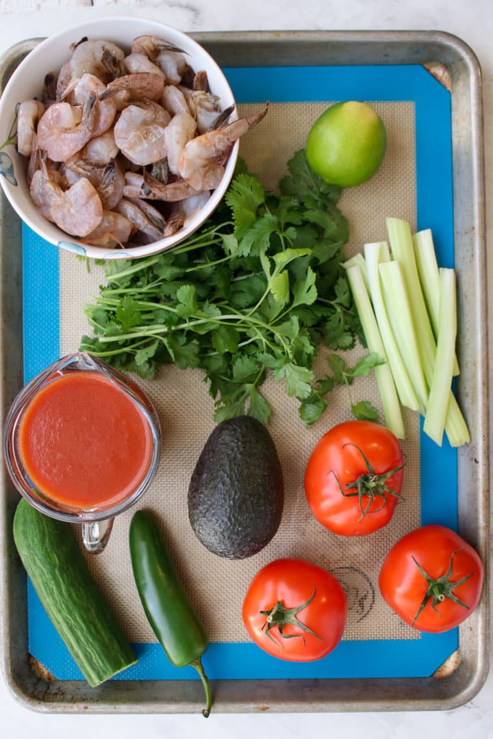 cutting board with the ingredients to make Mexican shrimp cocktail