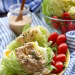 two wedges of iceberg lettuce with thousand island dressing