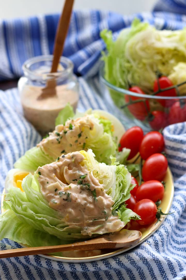 two wedges of iceberg lettuce with thousand island dressing