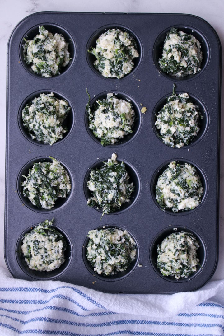 spinach pie bites in a baking pan ready to go in the oven