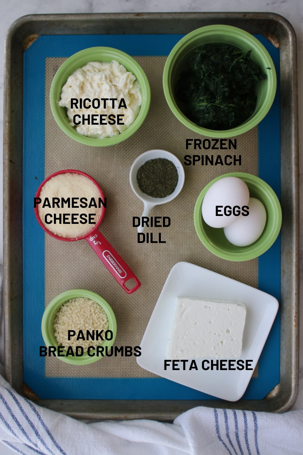 ingredients to make spinach pie bites on a baking sheet