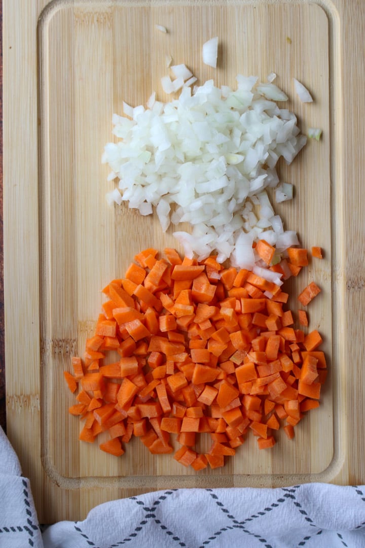 diced onions and carrots on a cutting board