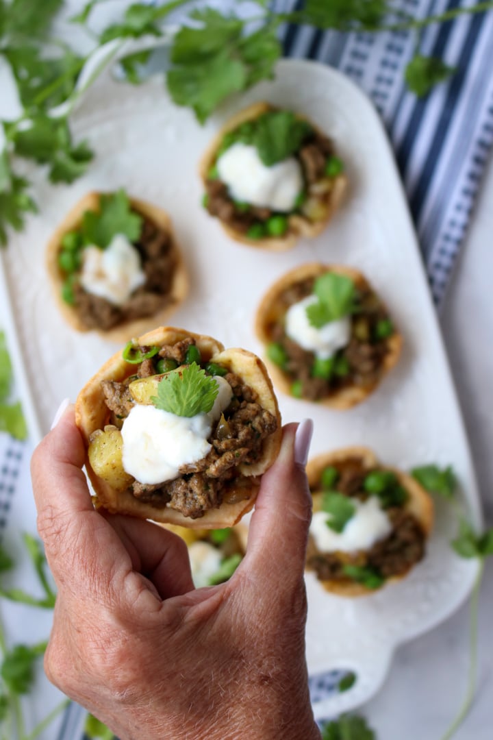 woman's hand holding a mini beef pie