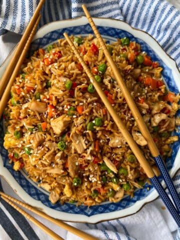 Large bowl of rotisserie chicken fried rice with two sets of chop sticks
