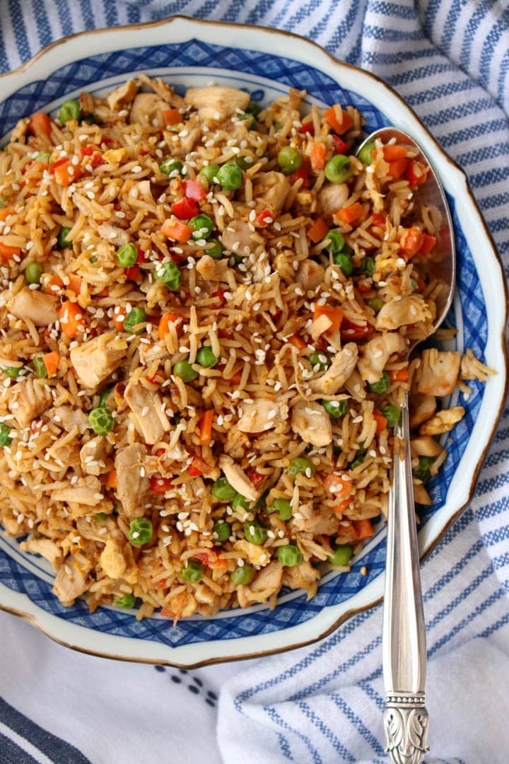 Large bowl of rotisserie chicken fried rice with a large serving spoon on the right side