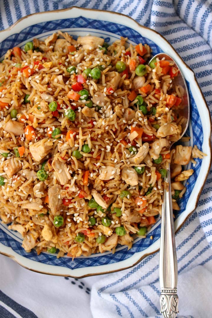 Large bowl of rotisserie chicken fried rice with a large serving spoon on the right side