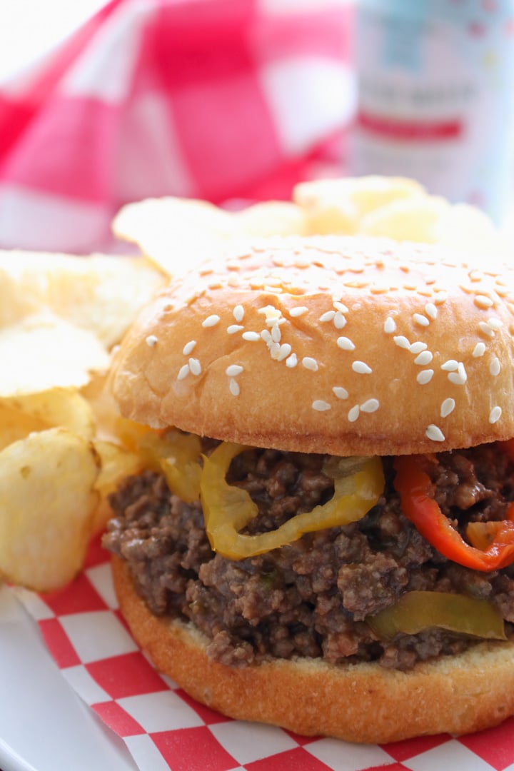 SLOPPY JOE ON SESAME SEED BUD GARNISHED WITH BANANA PEPPERS