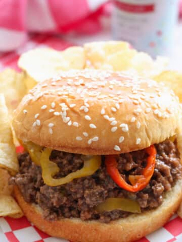 SLOPPY JOE ON SESAME SEED BUD GARNISHED WITH BANANA PEPPERS