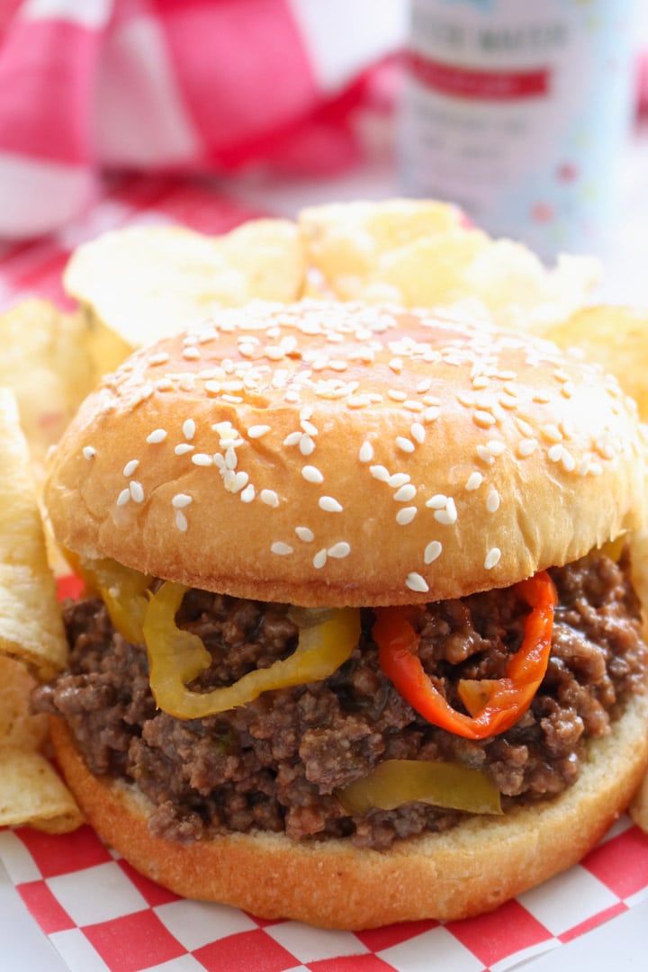 SLOPPY JOE ON SESAME SEED BUD GARNISHED WITH BANANA PEPPERS