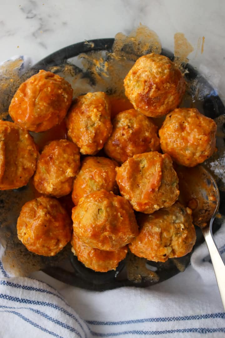 buffalo meatballs being tossed with sauce