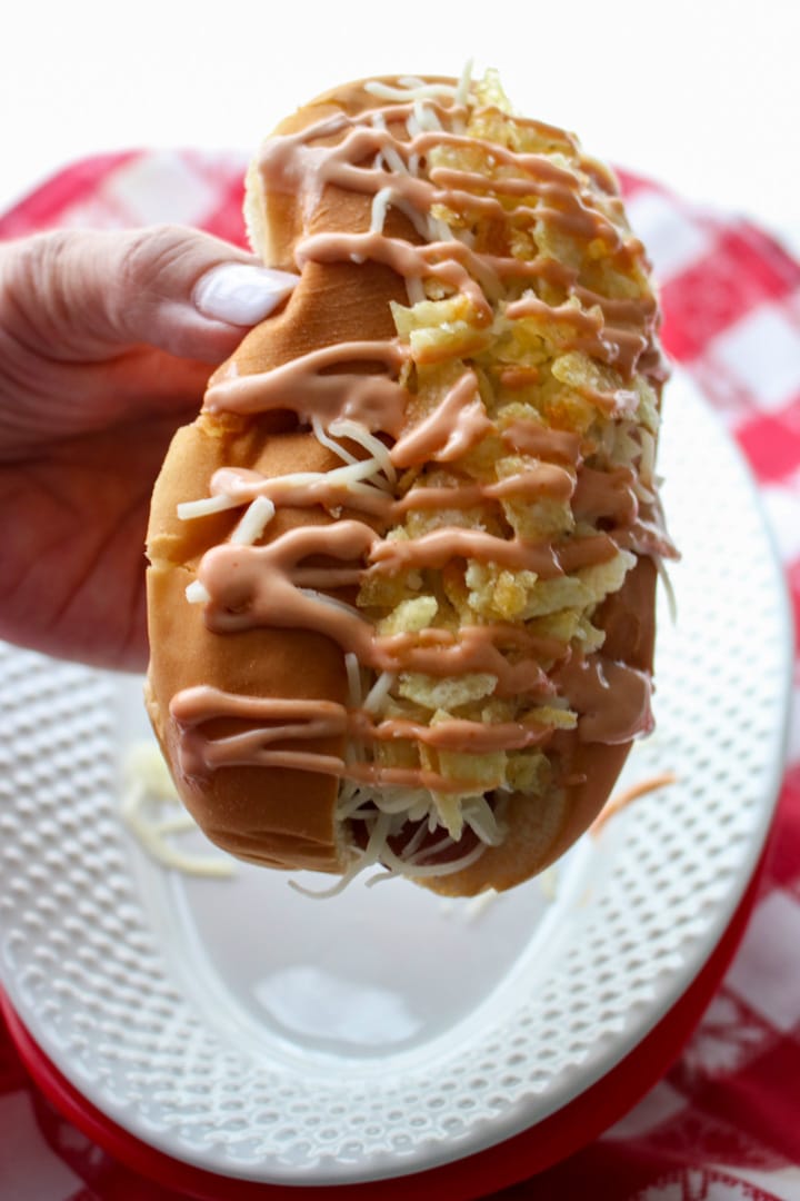 Woman's hand holding a COLUMBIAN-STYLE HOT DOG