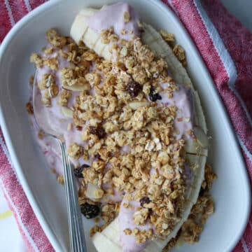 Sliced banana with pink blended cottage cheese and granola