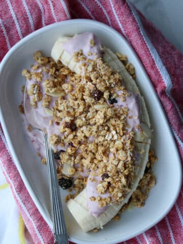 Sliced banana with pink blended cottage cheese and granola