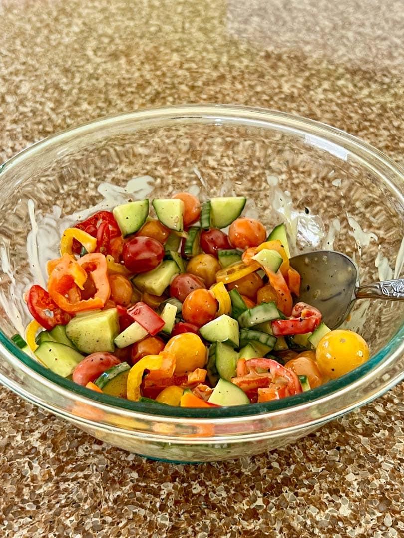 sliced cucumber, tomatoes, and peppers in a bowl